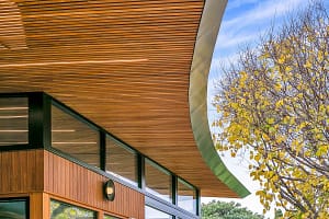 Modern architectural design by Finch Constructions in Adelaide, showcasing a custom-built curved wooden roof with large windows.