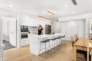 Contemporary kitchen renovation in Adelaide by Finch Constructions, featuring a sleek white design, large island bench, and modern appliances."